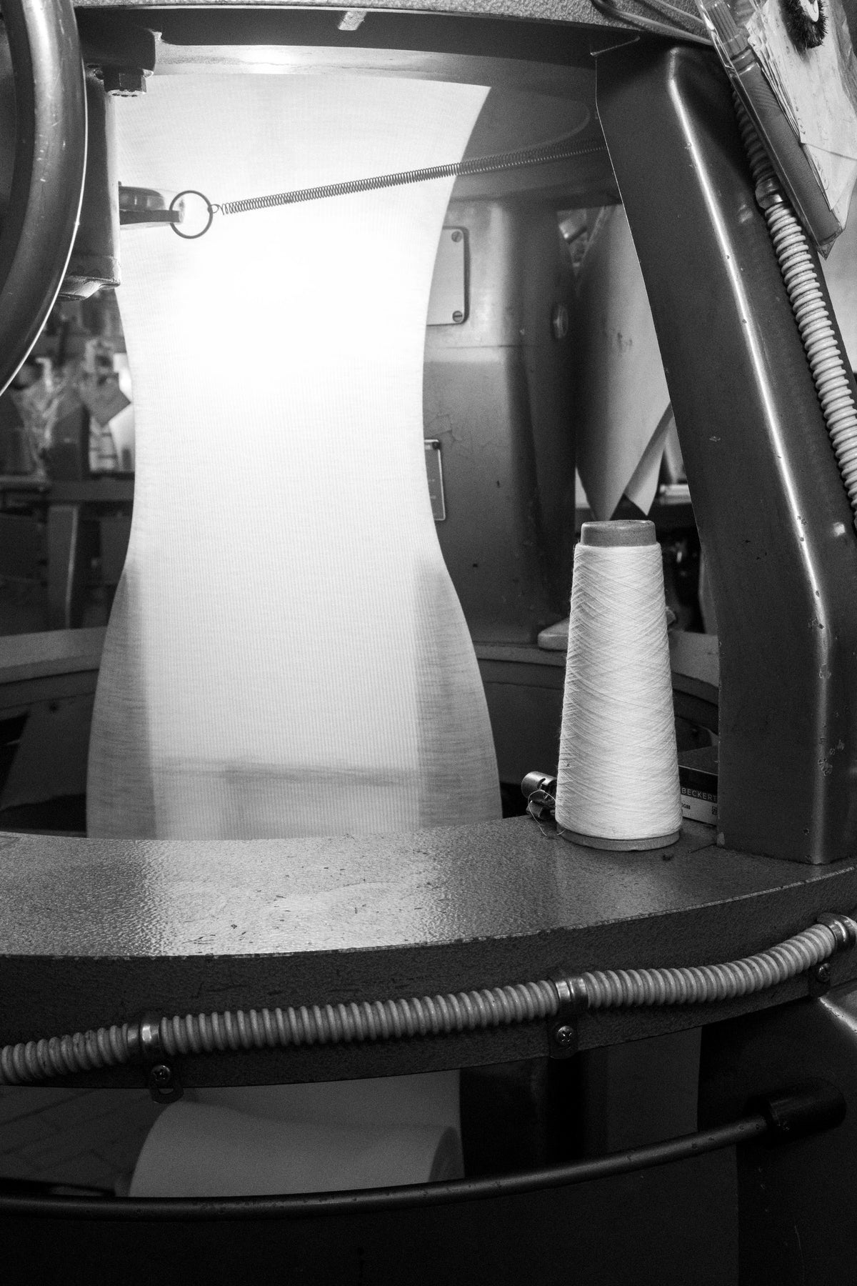 Cono de hilo alimentando una máquina circular de tejido en Turín
